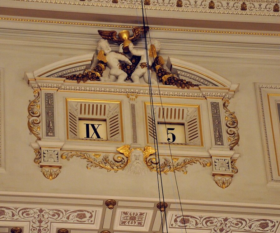The five-minute clock above the stage of the Semper Opera, showing IX and 5 in two gilded frames
